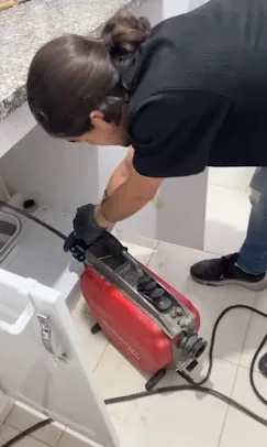 Bir teknisyenin gider hattında robotla müdahale yaptığı dar kadraj.
